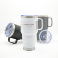 A white Langston vacuum insulated travel tumbler with a handle and clear lid, shown in front of a dark gray tumbler and a black tumbler with lid off on a white background.