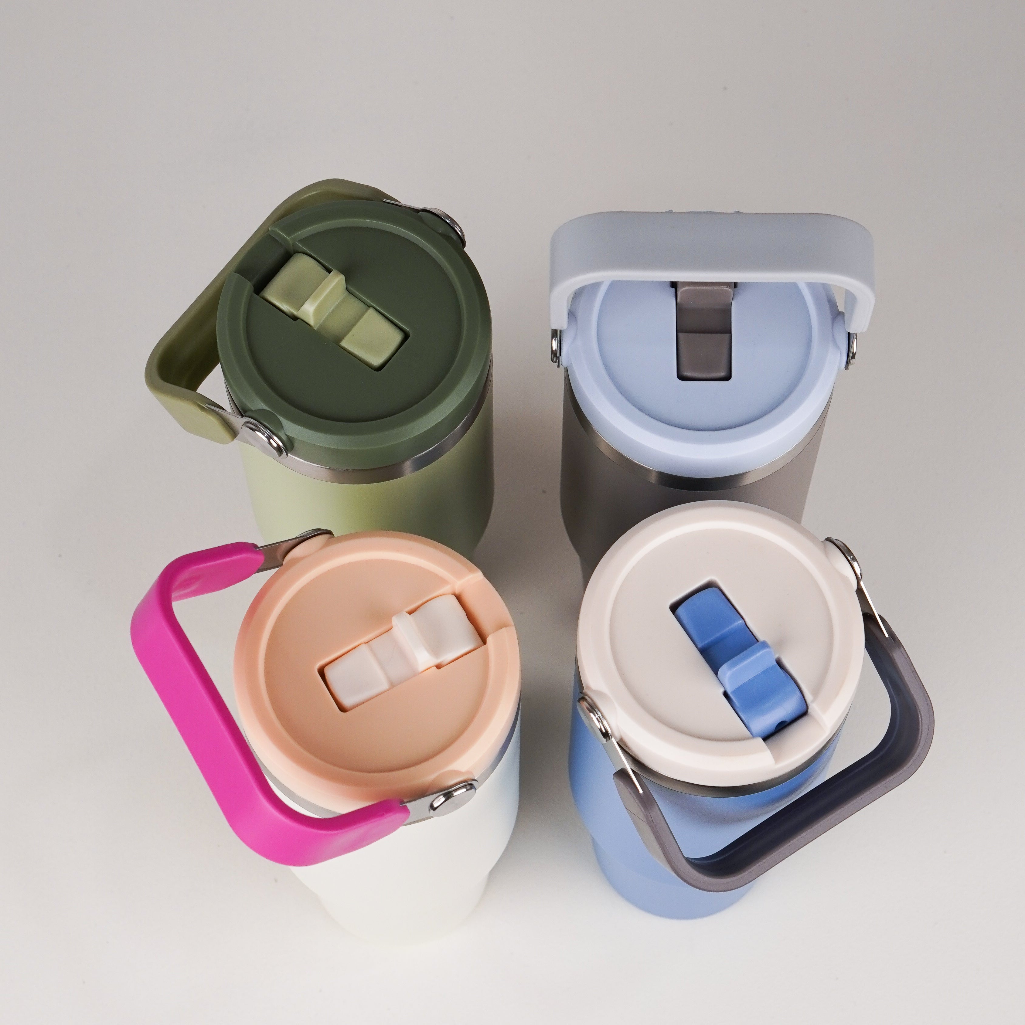 Four colorful water bottles with lids on a light gray background