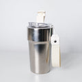 A stainless steel travel tumbler with a clear lid, cream-colored flip-top straw, and a matching fabric wrist strap, shown on a light gray background.